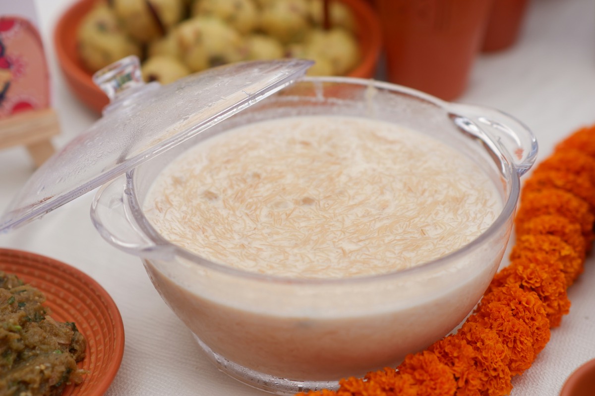Rice payesh in a glass bowl, set among marigolds