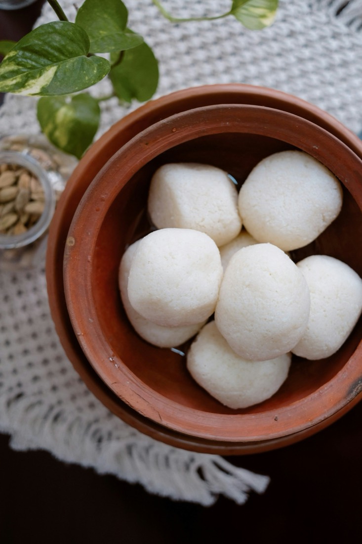 White rosogollas resting in syrup in an earthen pot